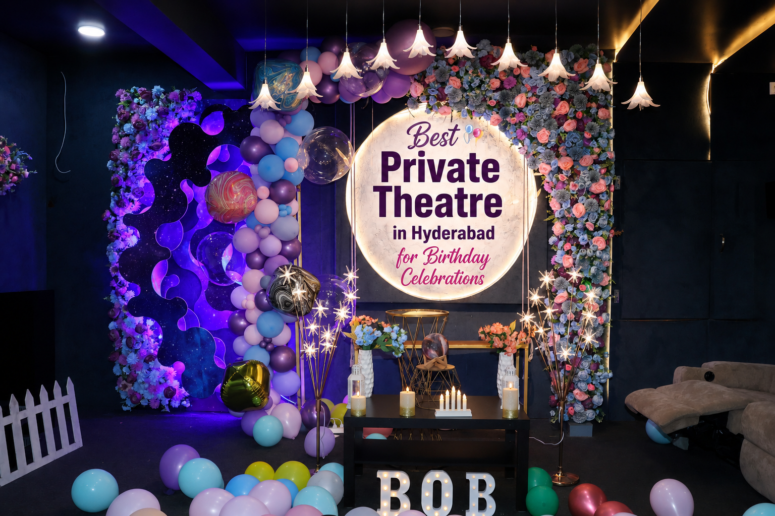 Decorated private theatre set up for a birthday celebration in Hyderabad, with colorful balloons, a flower wall, warm lighting, and a table setup.